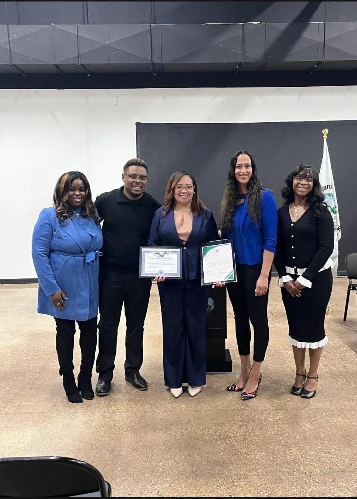Board members and leadership holding certificates of recognition at an official ceremony