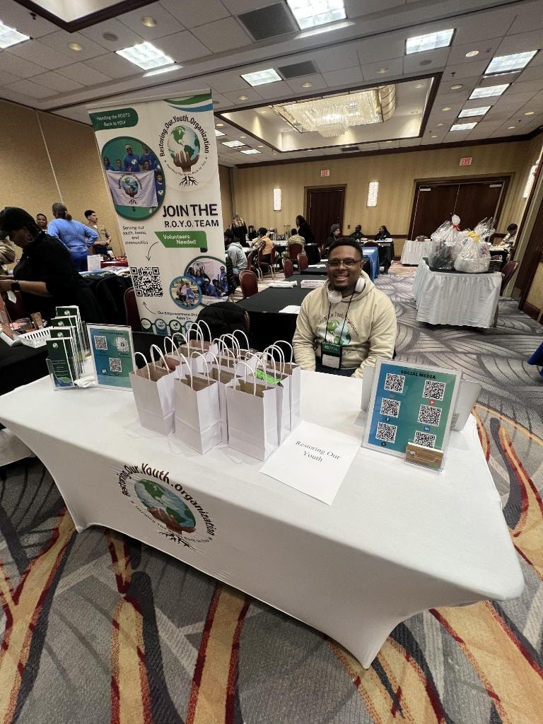 R.O.Y.O. booth at community conference with branded table and banner