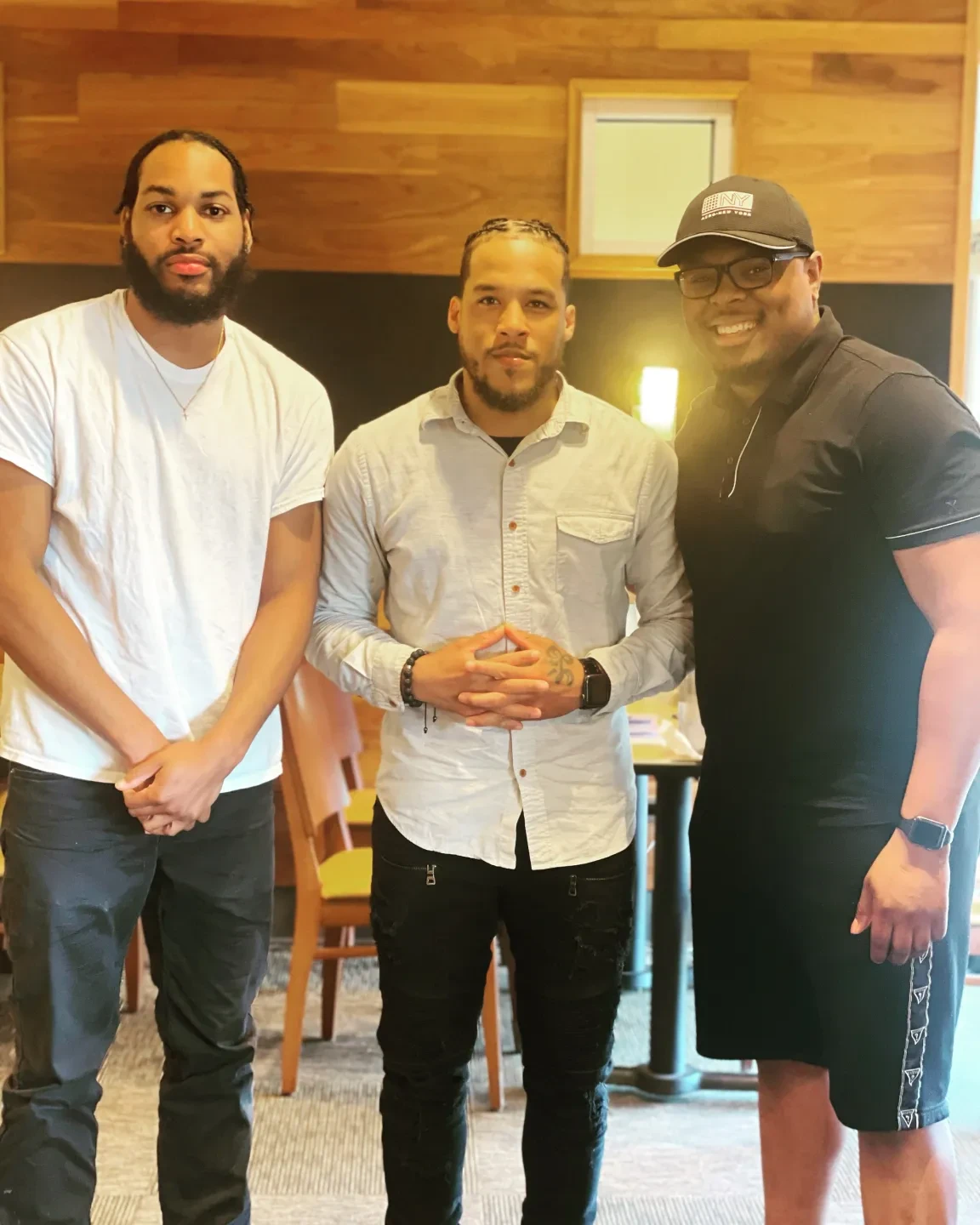 Three men posing together at a program event
